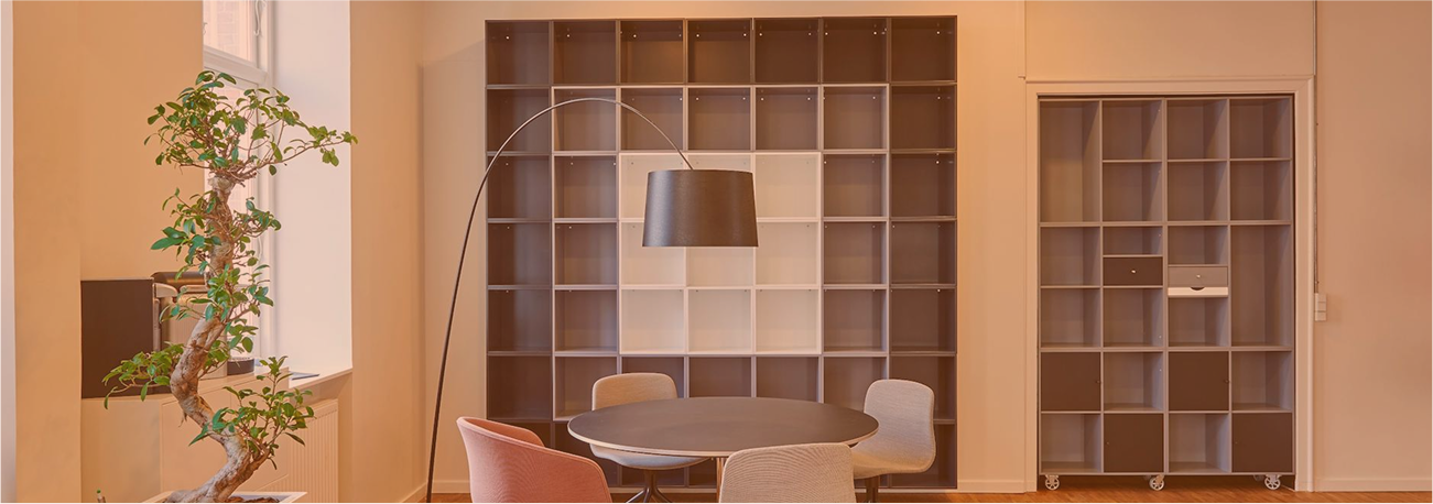 Modern office interior with bonsai plant, floor lamp, and meeting table